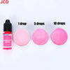 A bottle of fluorescent fuschia liquid candle dye with dropper tips next to three pink cosmetic discs showing 1, 5, and 10 dr