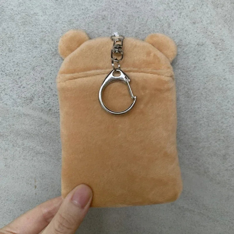 A tan Rilakkuma plush item with a silver keychain attached.