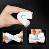 A hand holds a white melamine foam cleaning sponge shaped like a letter L, demonstrating its flexible form.