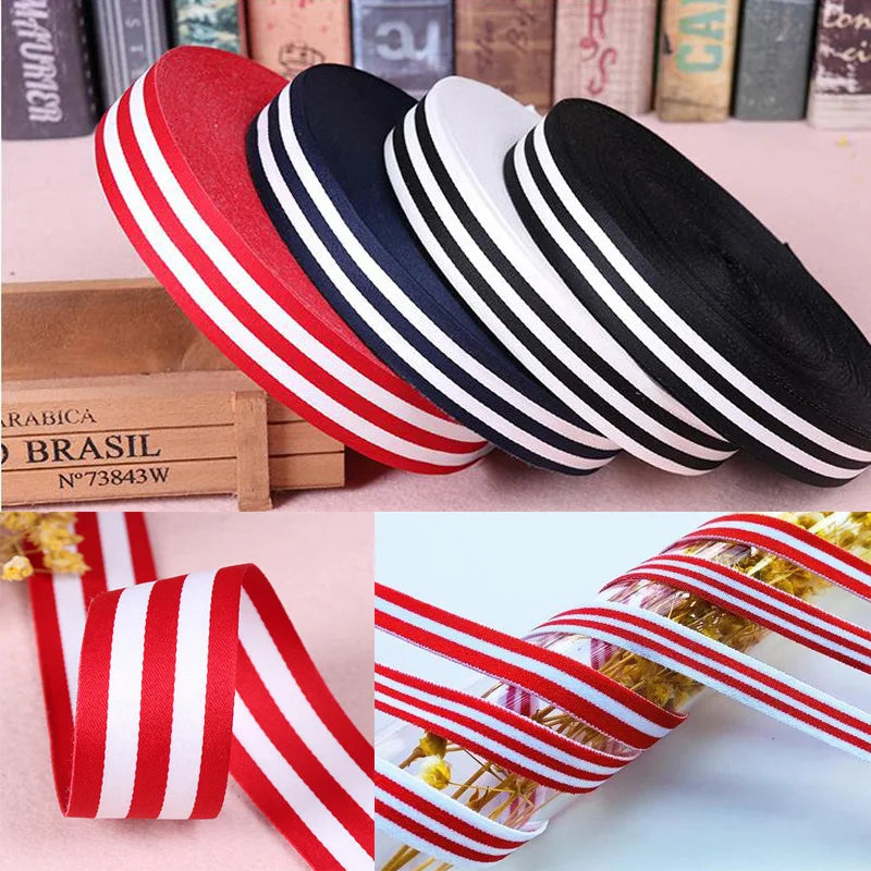 A collection of red, white, and black grosgrain ribbons displayed on a wooden box.
