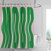 A green and pink abstract geometric art shower curtain hanging on a rod.