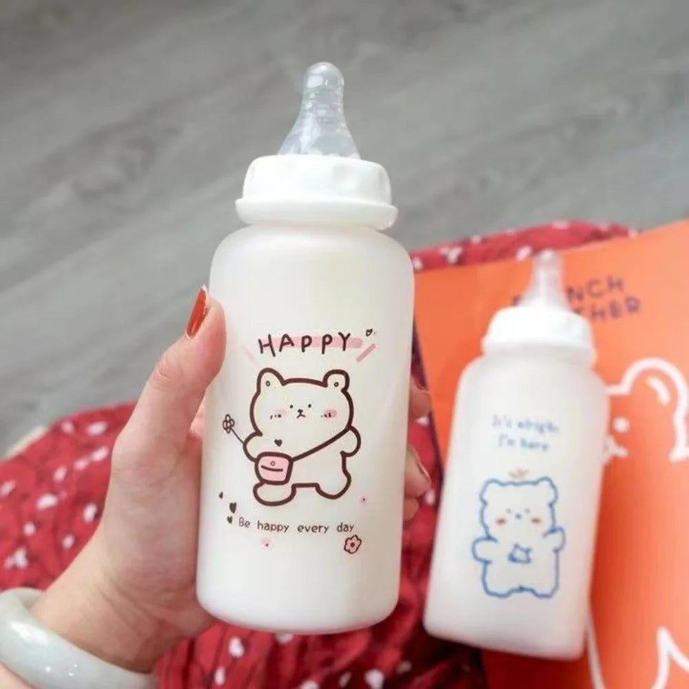 A hand holds a white plastic water bottle with a happy bear design and text, next to another similar bottle.