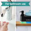 Une main distribue du savon d'une pompe électrique noire et bleue pour la salle de bain.