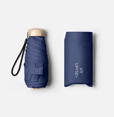 A dark blue compact folding UV protection umbrella with a light-colored handle.