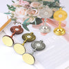 A collection of mini metal religious ornaments featuring floral designs and the initials JHS, displayed on a white background