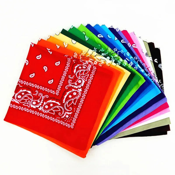 A fan of colorful square printed fabric scarves and bandanas arranged in a rainbow gradient.