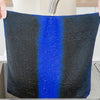 A black microfiber cleaning cloth with a vertical blue stripe being rinsed under a faucet.