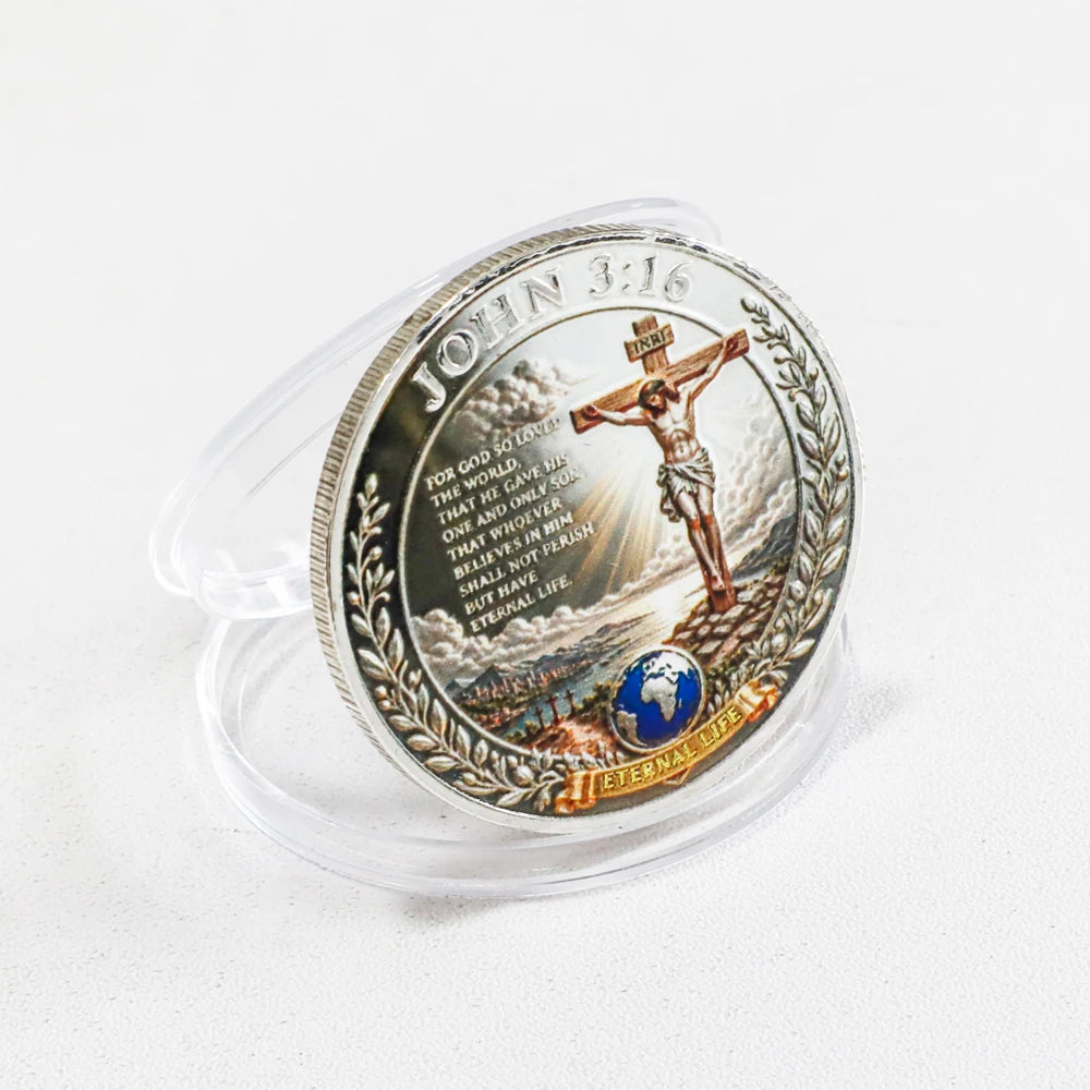 A commemorative coin featuring John 3:16 and a depiction of the crucifixion on a silver disc.