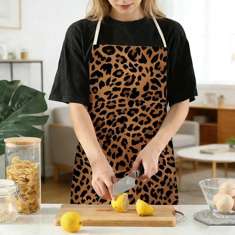 A person wearing a leopard print kitchen apron is cutting a lemon on a wooden board.
