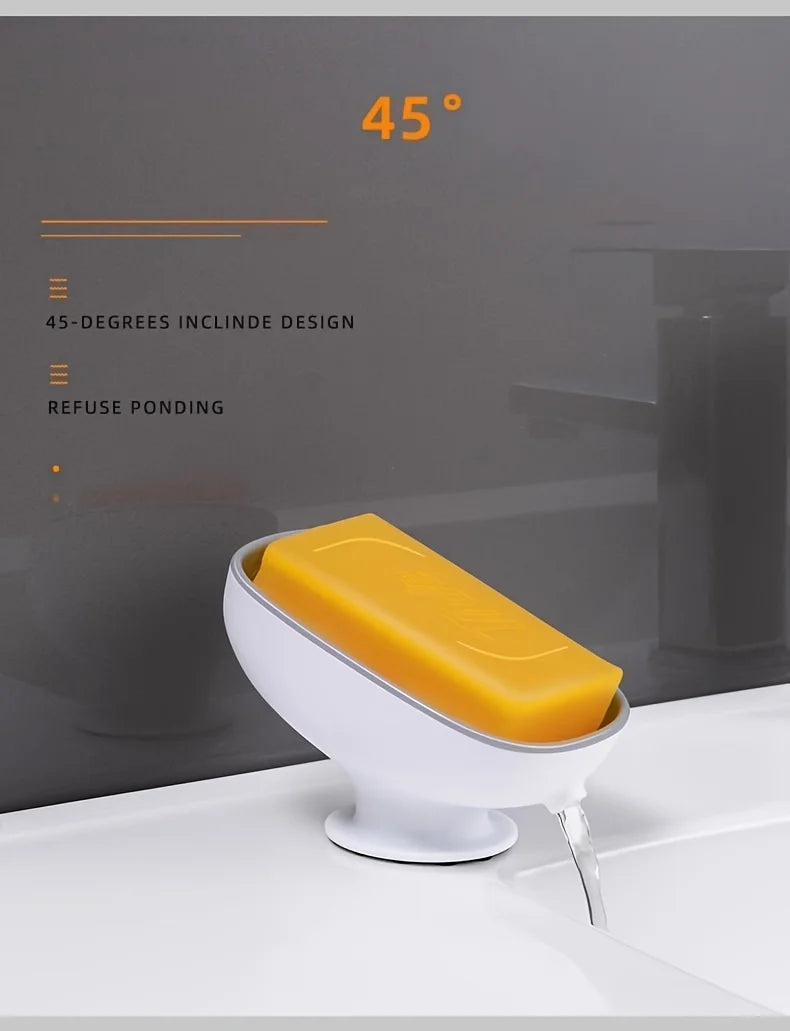 A yellow leaf-shaped bathroom soap dish drainer with a 45-degree incline design is shown on a white surface.