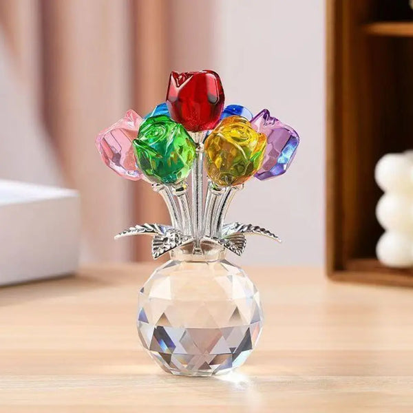A sculpture of colorful crystal roses arranged in a glass vase on a wooden surface.