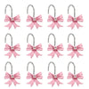 A set of twelve pink decorative bow tie shower curtain hooks with silver metal rings.