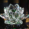 A clear crystal lotus flower centerpiece with green accents, displayed on a dark reflective surface.