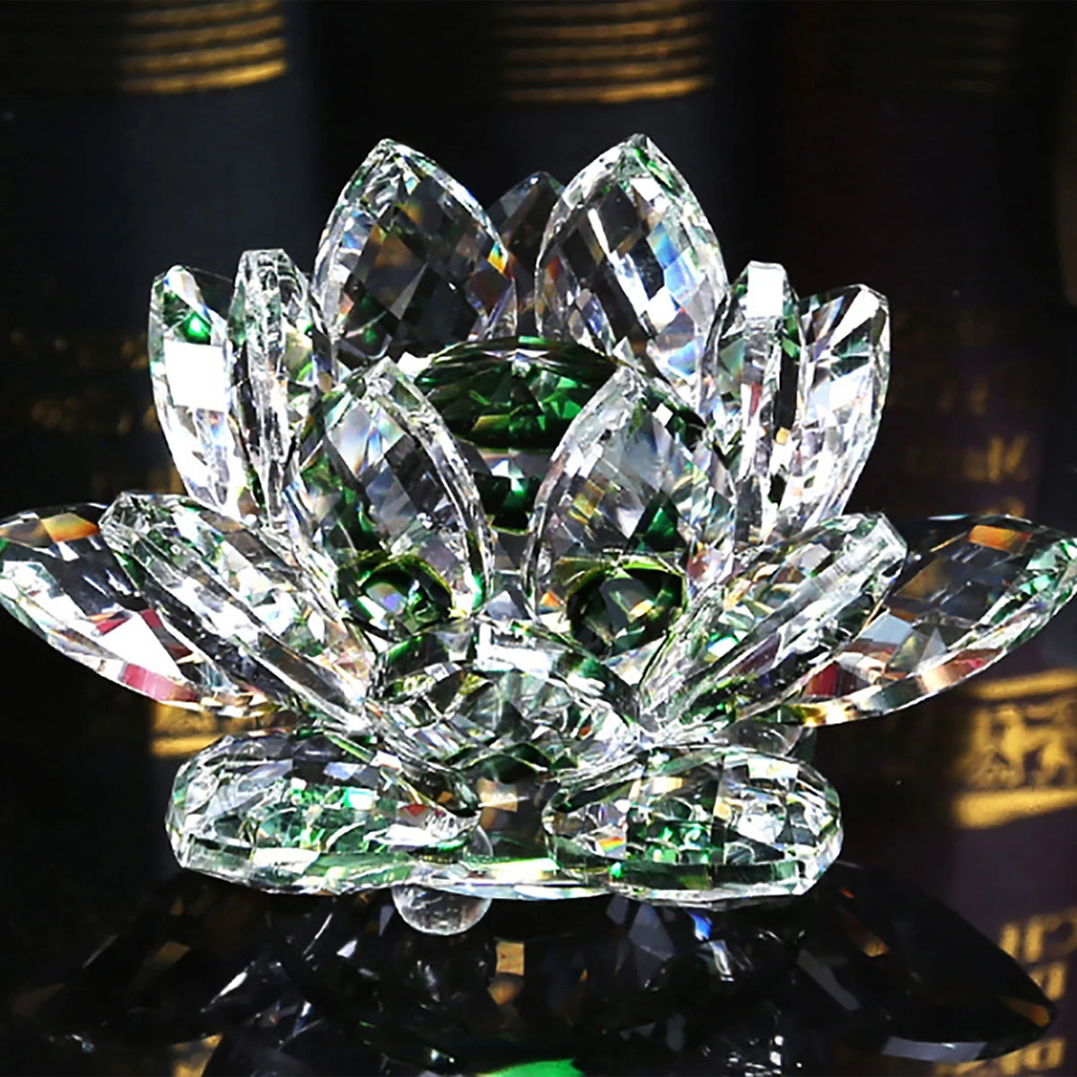 A clear crystal lotus flower centerpiece with green accents, displayed on a dark reflective surface.