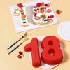 Red silicone number cake molds shaped like the number 18 displayed next to decorated strawberry pastries.