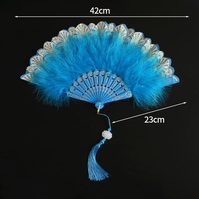 A bright blue lace fabric folding hand fan with a decorative fan and tassel, shown against a black background.