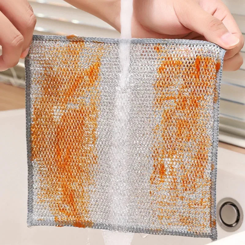 Eine Hand hält ein feuchtes Maschenreinigungstuch mit orange-grauen Fasern.