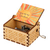 A vintage engraved wooden music box with a lid featuring a sun design.