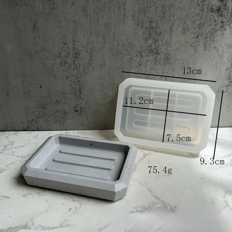Klares Silikon-Seifenspeichertablett neben einer grauen Epoxidharzform mit Maßenangaben.