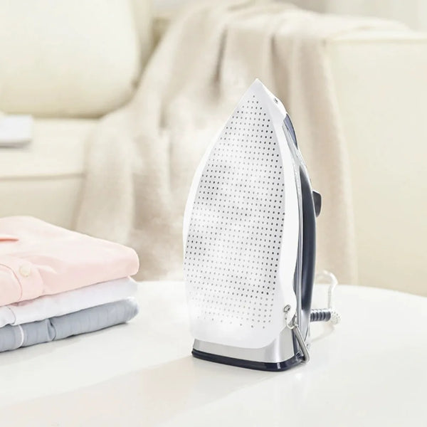 A white protective iron shoe cover with a perforated surface is displayed on a white table.
