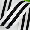 A close-up of a black and white striped grosgrain ribbon rolled for crafting.