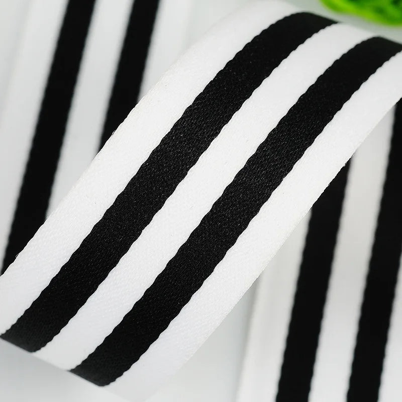 A close-up of a black and white striped grosgrain ribbon rolled for crafting.