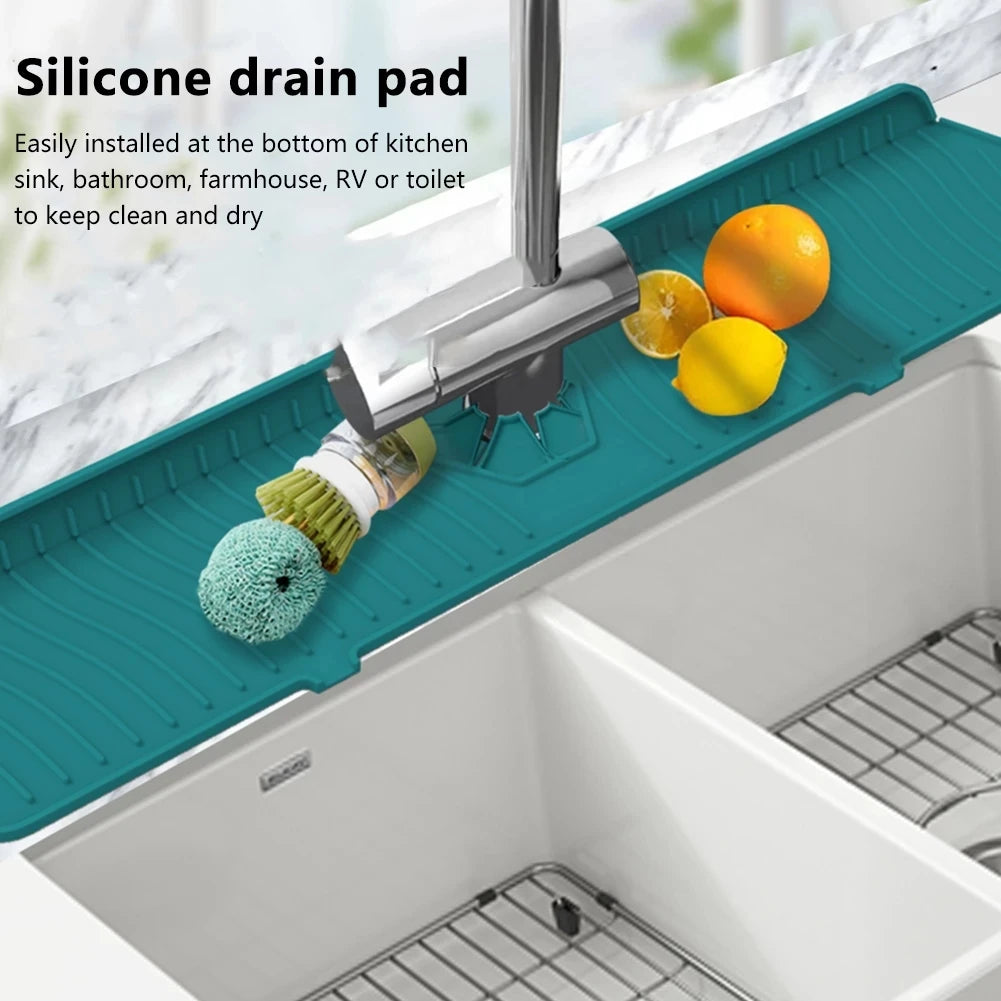 A silicone drain pad is installed at the bottom of a kitchen sink, positioned under a faucet and surrounded by citrus fruits.
