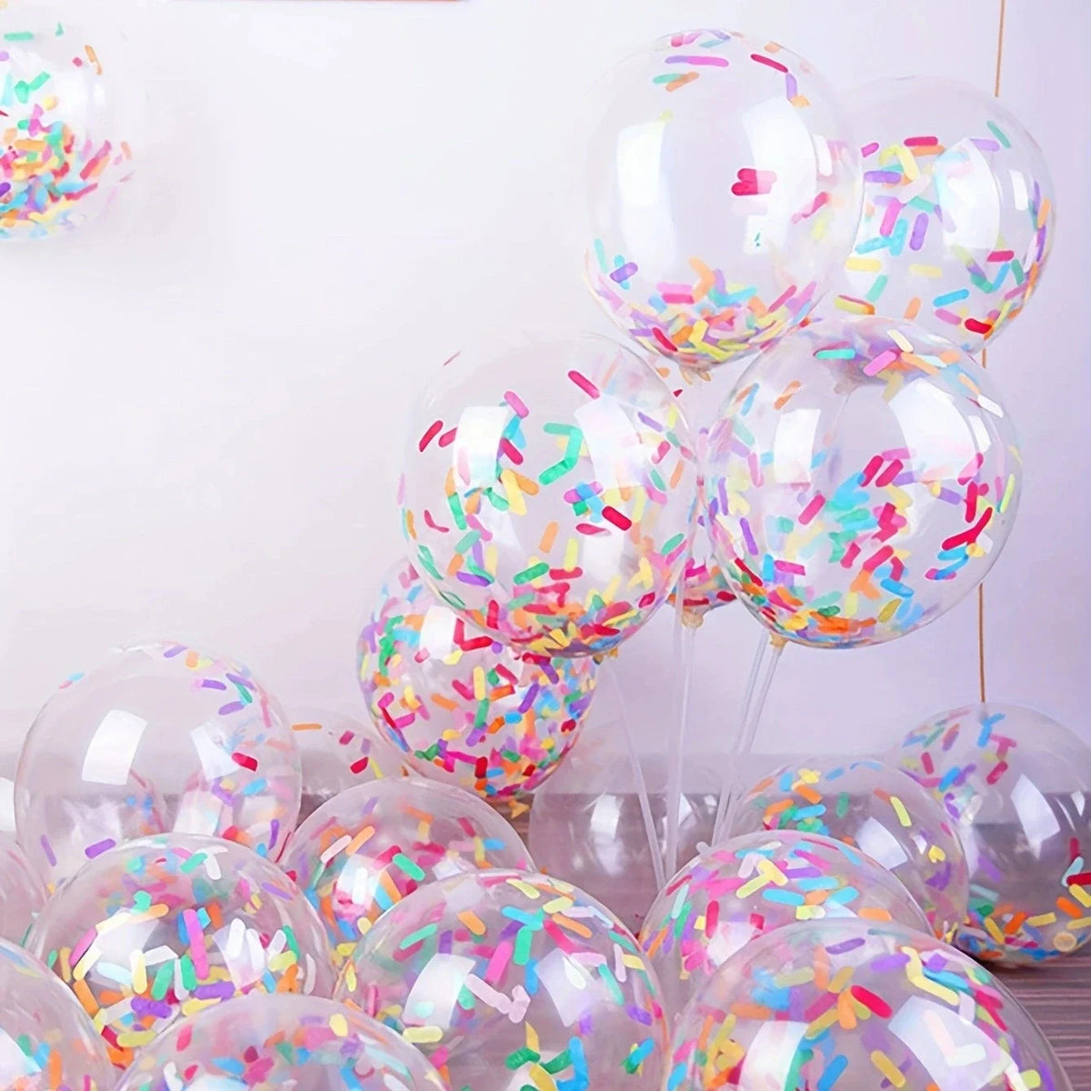 Clear balloons filled with pink and multicolored confetti decorations