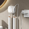 A white portable UV electric toothbrush cleaner device mounted on a wall with attached charging cables.