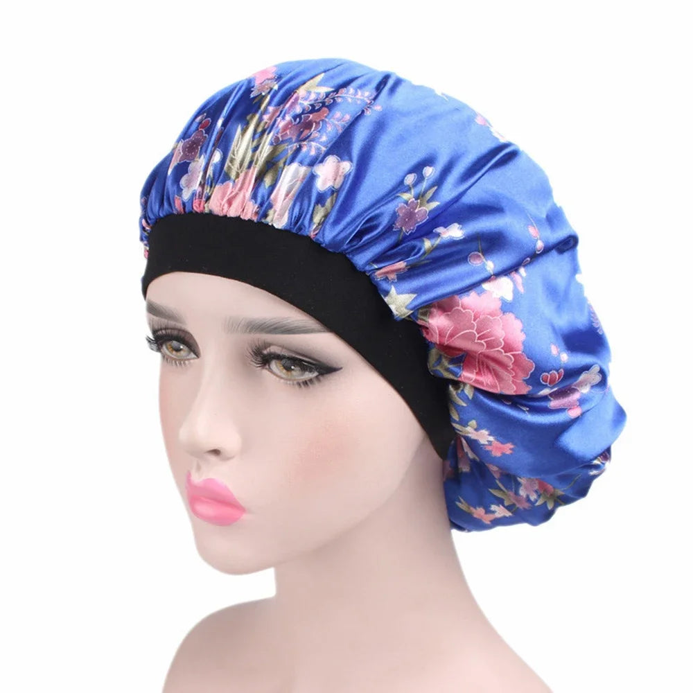 A woman wearing a blue satin sleep bonnet with floral embroidery.