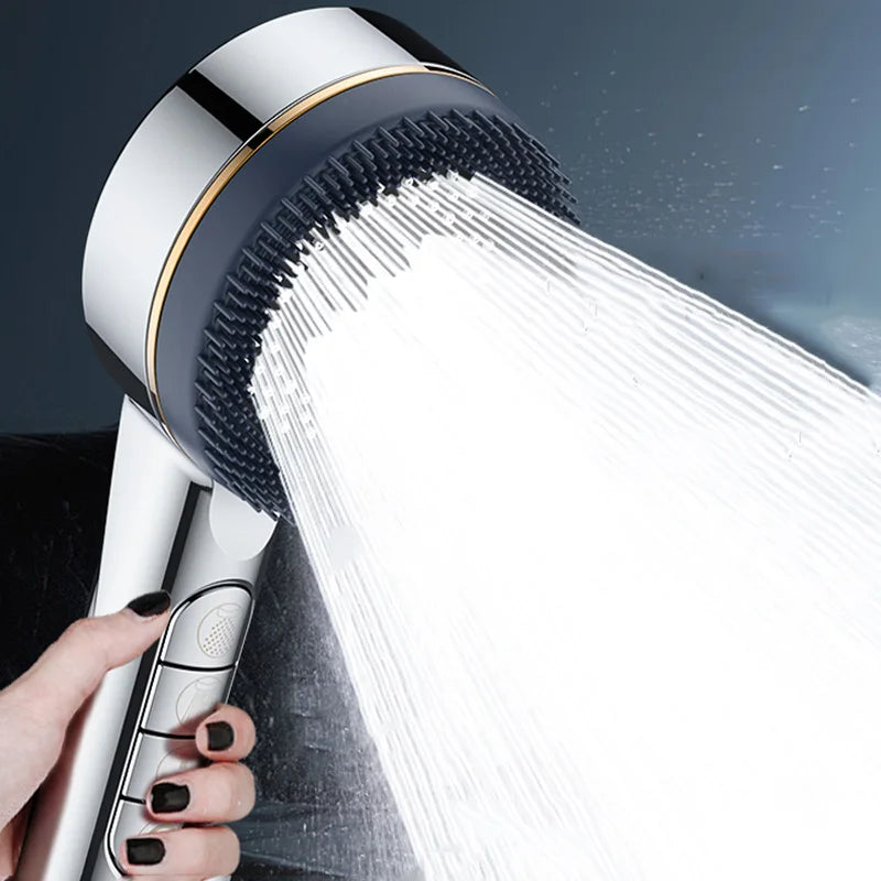 A hand is holding a silver shower head with a powerful stream of water spraying out.