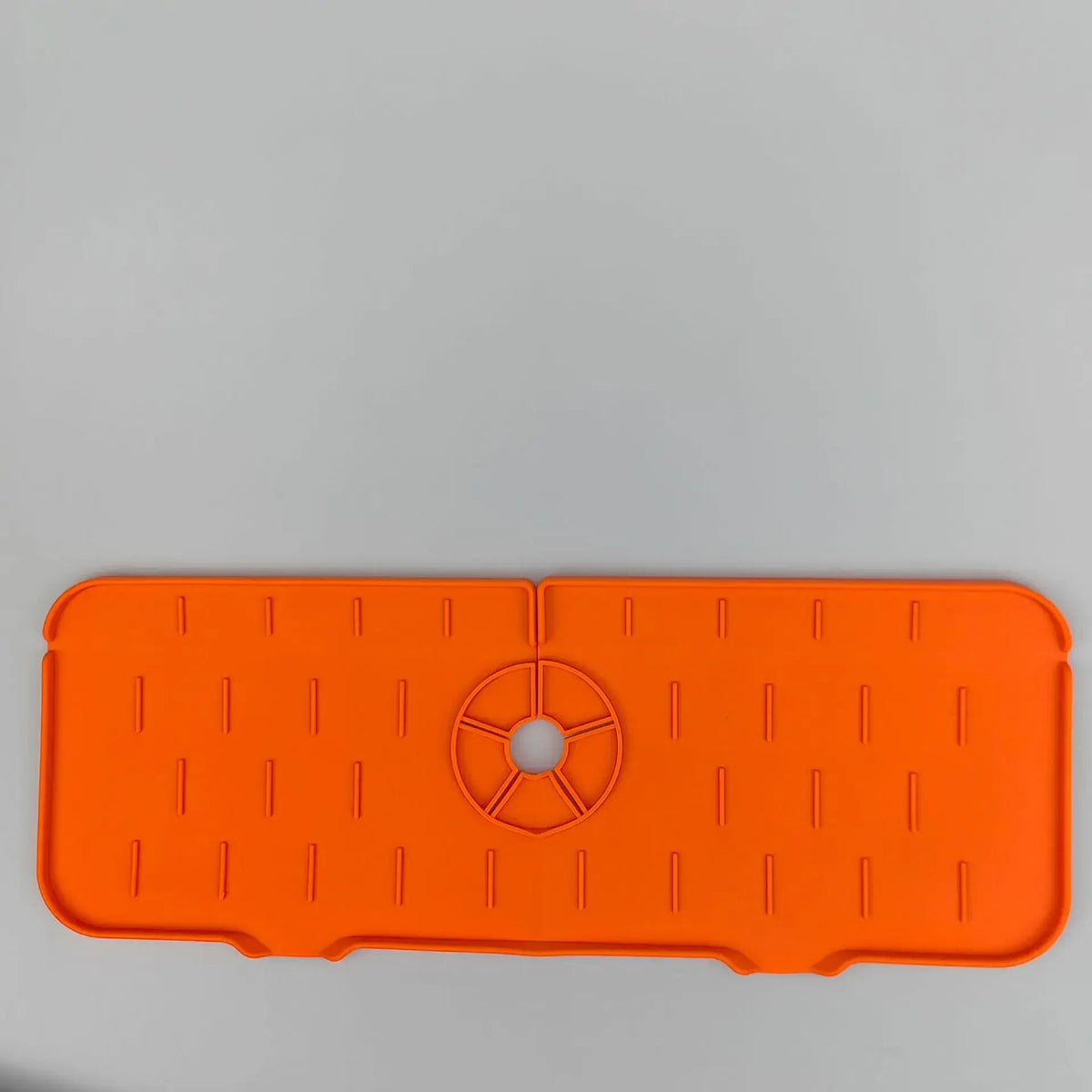 Orange silicone kitchen sink drainer and splash guard mat with textured surface