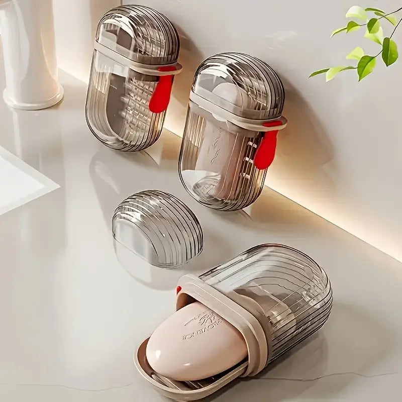 Collection de boîtes de savon de voyage en verre transparent avec couvercles scellés et savon rose, présentées sur une surfac