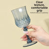 A hand holds a clear glass champagne flute with a textured grip, suitable for daily use or gatherings.