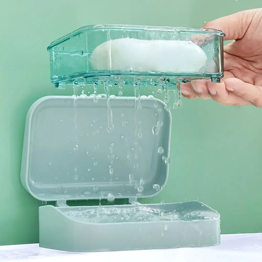 A hand is pouring white soap into a transparent drainage soap dish, which is resting on a larger, similar-colored dish.