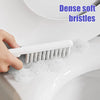 Eine Hand benutzt eine weiße Bürste mit dichten, weichen Borsten, um das Innere einer Toirrspülung zu reinigen.