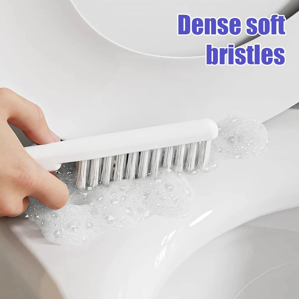 Eine Hand benutzt eine weiße Bürste mit dichten, weichen Borsten, um das Innere einer Toirrspülung zu reinigen.