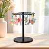 A black stand with multiple colorful plastic and wooden charms for hanging glasses, placed on a light wood surface.