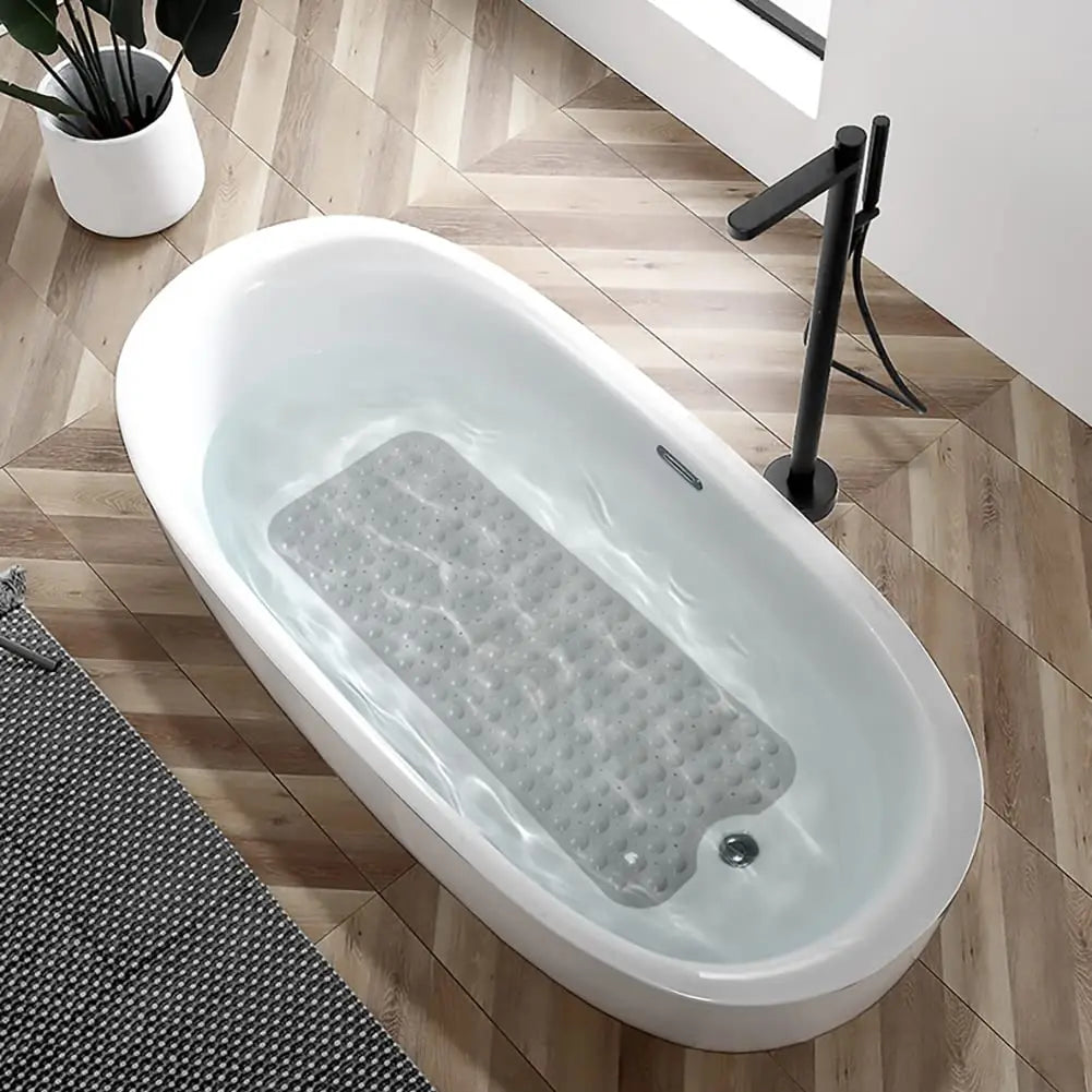 A white bathtub filled with water and a non-slip mat featuring suction cups is visible on a wooden floor.