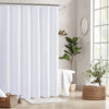White waffle weave shower curtain hanging on a metal rod in a bathroom setting