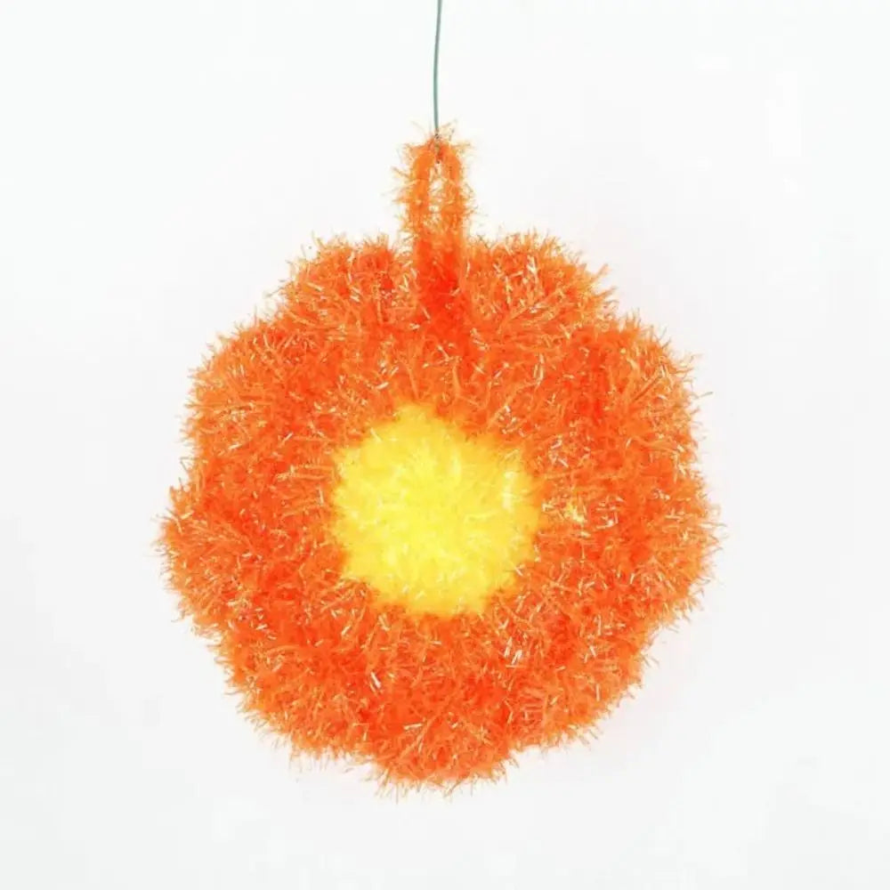 A bright orange, fluffy, spherical non-stick acrylic dish towel for kitchen cleaning.