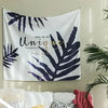 A white tapestry featuring dark blue palm leaves and the text Make the Day Unique.