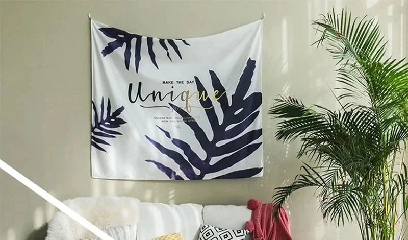 A white tapestry featuring dark blue palm leaves and the text Make the Day Unique.