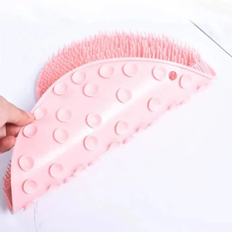 Alfombrilla de ducha de silicona rosa para masajes de pies con cerdas, sostenida y exhibida sobre fondo blanco.