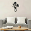 Black metal cross wall art featuring a carved face design displayed above a gray sofa.