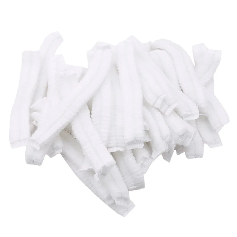 A pile of white disposable microblading hair net caps for permanent makeup.