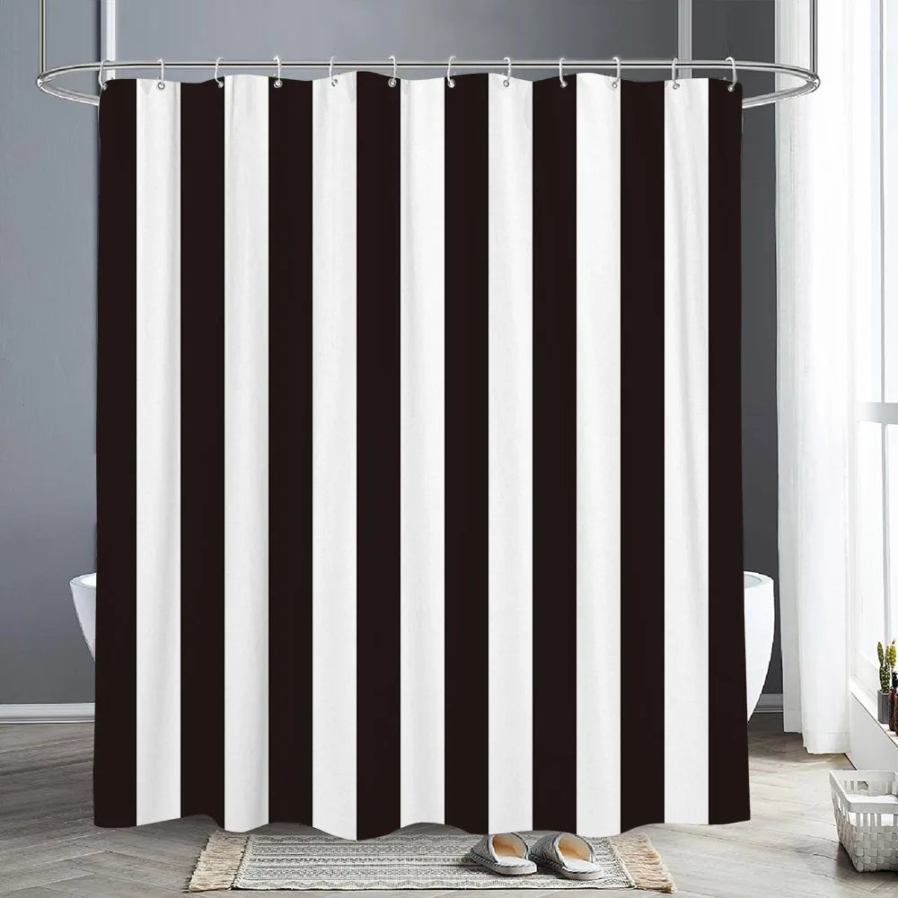 A shower curtain featuring vertical black and white stripes hanging from a metal rod.