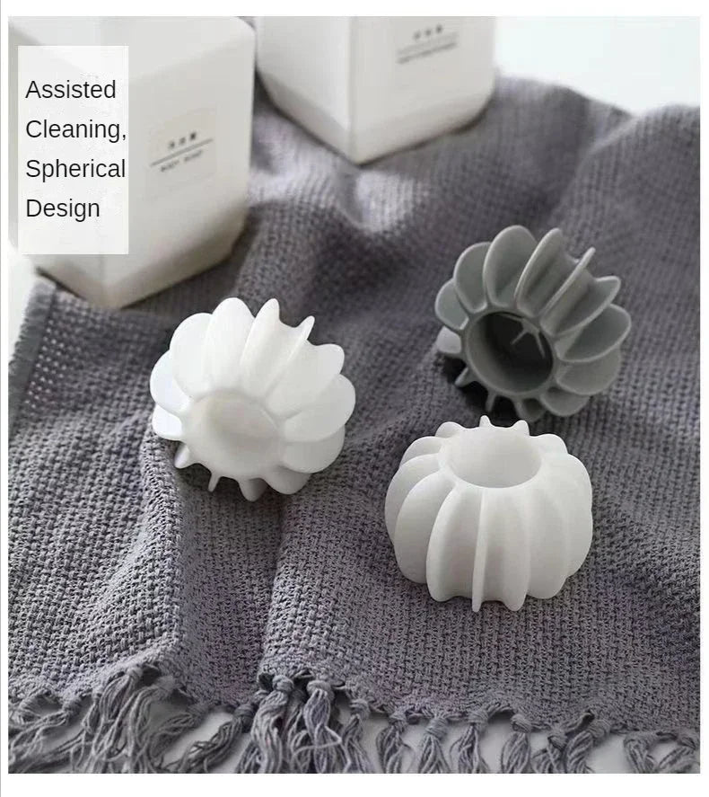 White and gray reusable laundry balls with spherical design shown on a textured cloth.