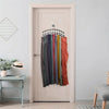 A set of curved metal hangers with ten clips for organizing clothing displayed on a white door.