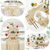 A beige boho sheer table runner draped over a white tablecloth with floral accents and natural elements.